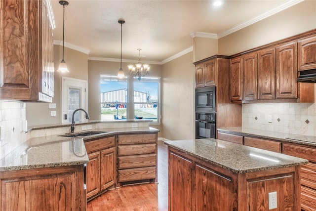 kitchen featuring light stone counters, backsplash, a sink, light wood-type flooring, and black appliances