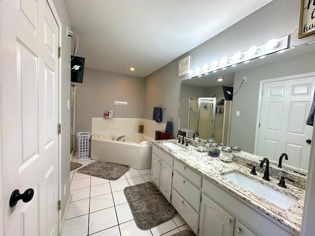 bathroom with a garden tub, a stall shower, tile patterned flooring, and a sink