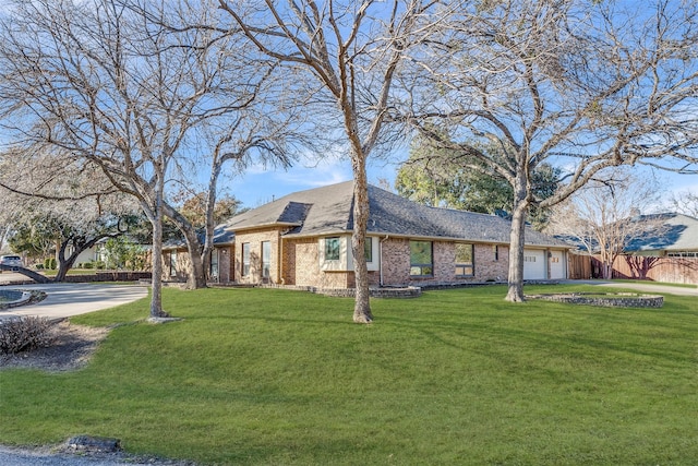 view of front of home featuring brick siding, an attached garage, fence, driveway, and a front lawn