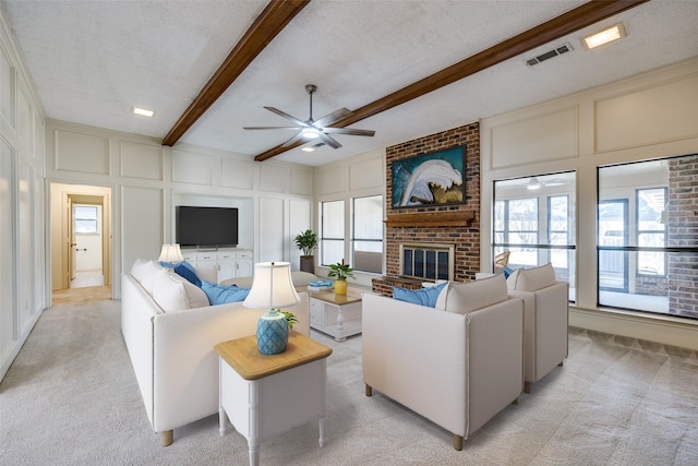 living room featuring a textured ceiling, beam ceiling, and a decorative wall