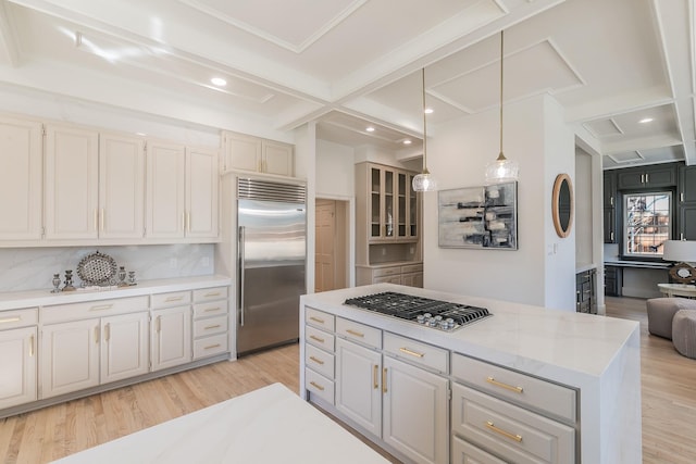 kitchen featuring stainless steel appliances, light wood-type flooring, beam ceiling, and decorative backsplash