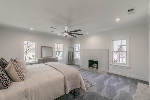 carpeted bedroom with a fireplace with flush hearth, multiple windows, visible vents, and baseboards