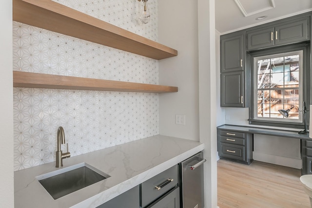 kitchen featuring a sink, light stone countertops, light wood-type flooring, open shelves, and backsplash