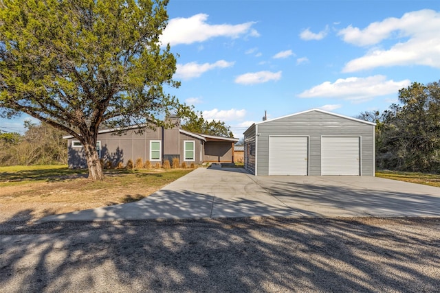 view of front facade with a garage, an outdoor structure, and stucco siding