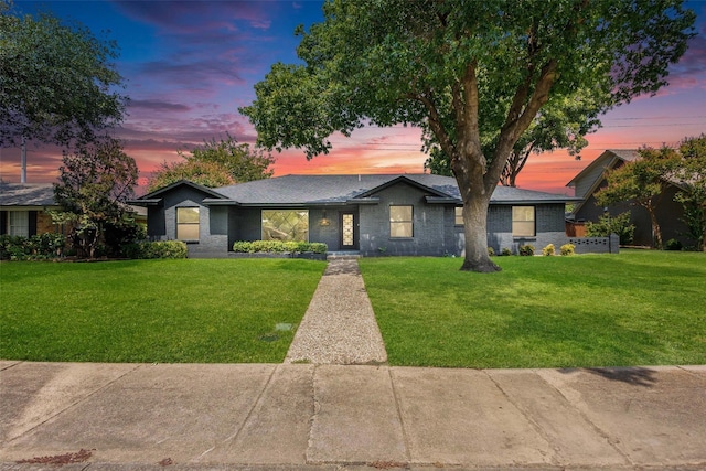 mid-century inspired home featuring brick siding and a yard