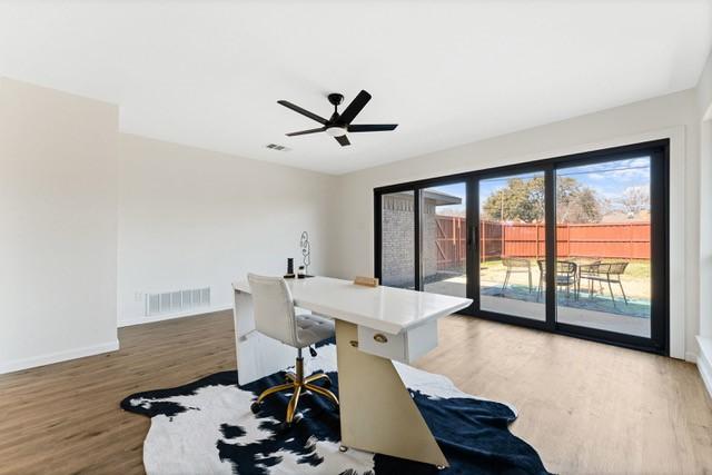 home office with a ceiling fan, visible vents, baseboards, and wood finished floors