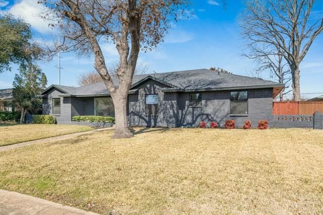 single story home with a front yard and fence