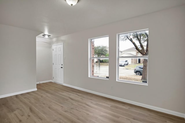 empty room featuring baseboards and wood finished floors