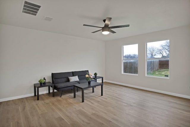 sitting room featuring ceiling fan, wood finished floors, visible vents, and baseboards