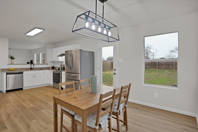 dining room featuring baseboards and light wood-style floors