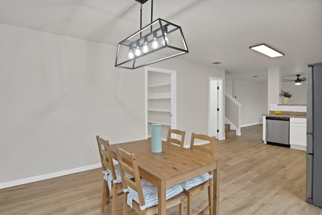 dining space featuring light wood-style floors, stairs, baseboards, and a ceiling fan