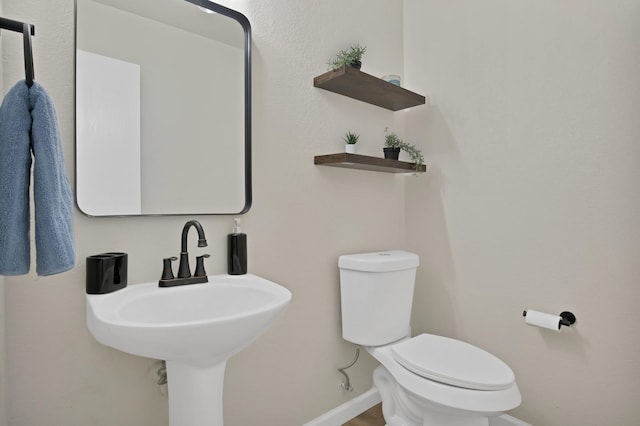 bathroom featuring toilet and baseboards