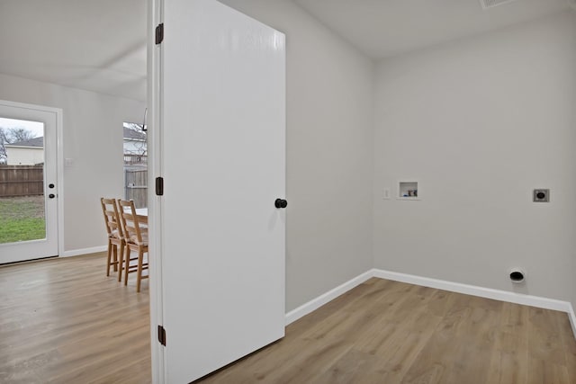 clothes washing area featuring wood finished floors, hookup for a washing machine, electric dryer hookup, and baseboards