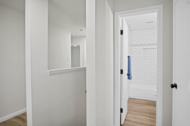 hall with baseboards and wood finished floors