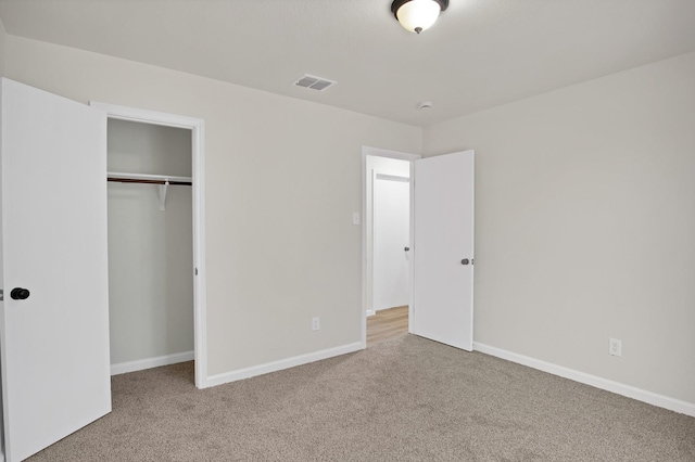 unfurnished bedroom with carpet, a closet, visible vents, and baseboards