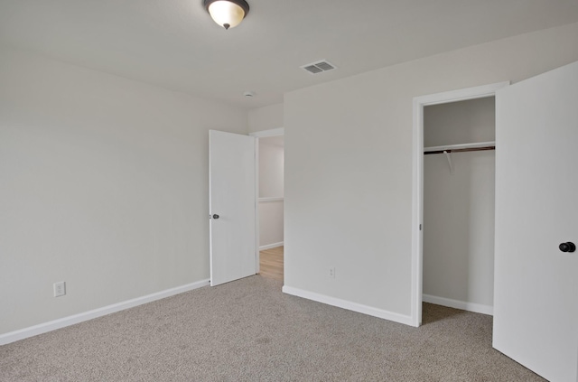 unfurnished bedroom featuring carpet floors, a closet, visible vents, and baseboards