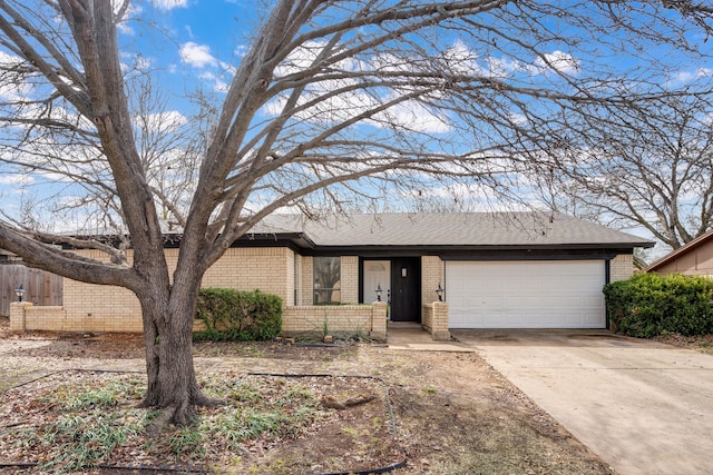 single story home featuring concrete driveway, brick siding, an attached garage, and roof with shingles