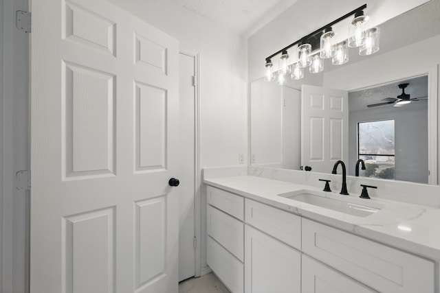 bathroom featuring marble finish floor, a ceiling fan, a textured ceiling, and vanity