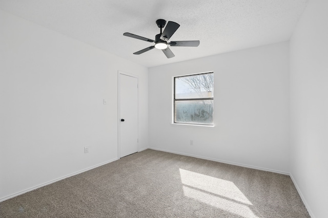 unfurnished room featuring a textured ceiling, carpet floors, a ceiling fan, and baseboards