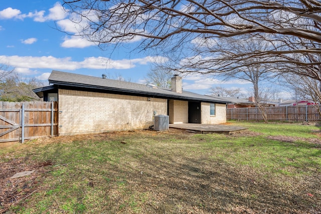 rear view of property featuring a patio, a fenced backyard, central air condition unit, brick siding, and a yard