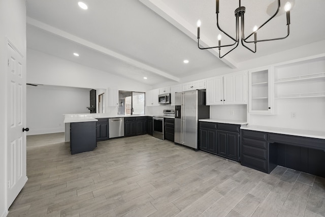 kitchen featuring lofted ceiling with beams, light wood-style flooring, a peninsula, a sink, and appliances with stainless steel finishes