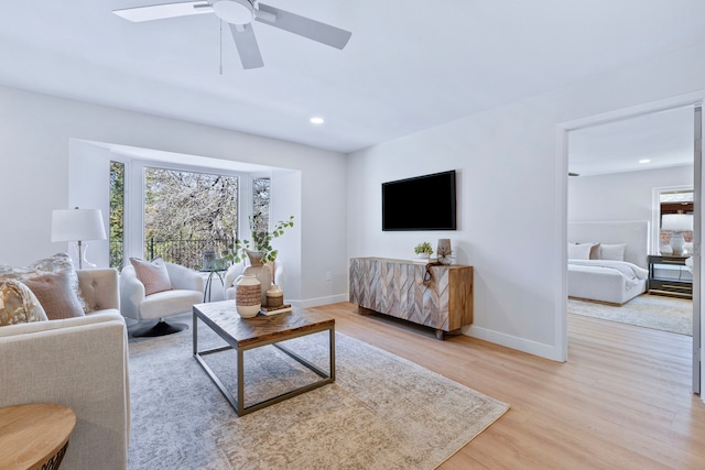 living area with light wood-style floors, recessed lighting, baseboards, and a ceiling fan