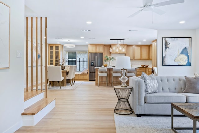 living area featuring light wood-style flooring, visible vents, baseboards, and recessed lighting