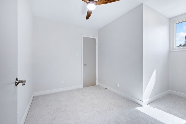 carpeted empty room featuring ceiling fan and baseboards