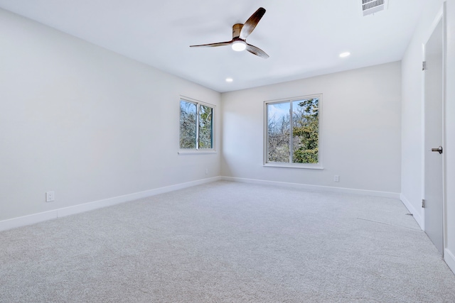 spare room featuring baseboards, visible vents, ceiling fan, and light colored carpet