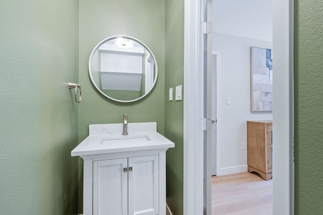 bathroom featuring wood finished floors, vanity, and baseboards