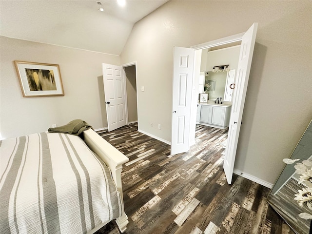 bedroom featuring lofted ceiling, a sink, dark wood finished floors, and baseboards