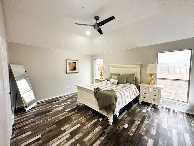 bedroom featuring multiple windows, vaulted ceiling, and dark wood-style flooring