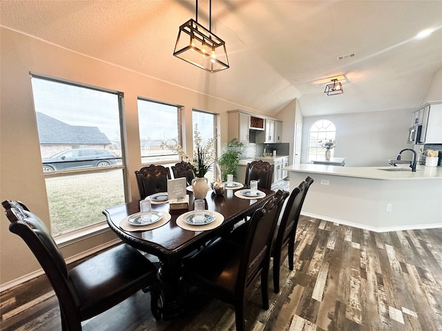 dining area with vaulted ceiling, dark wood finished floors, visible vents, and baseboards