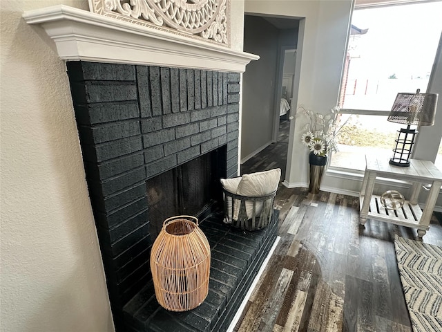 interior details featuring a fireplace, baseboards, and wood finished floors