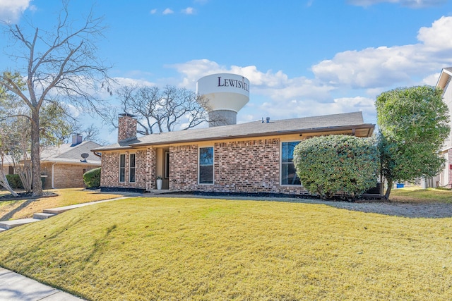 single story home with a front yard, brick siding, and a chimney