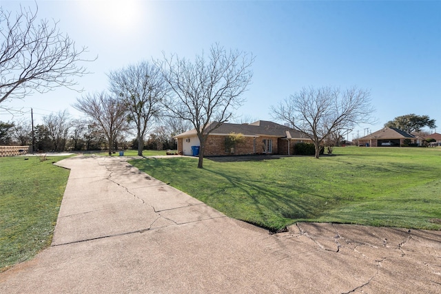 exterior space with brick siding and a front yard