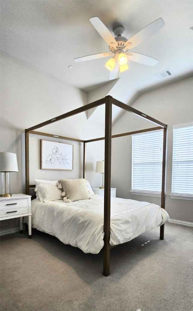 bedroom with carpet floors, visible vents, vaulted ceiling, and a ceiling fan