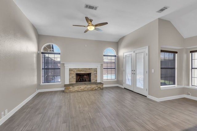 unfurnished living room with wood finished floors, visible vents, and a healthy amount of sunlight