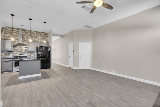 kitchen with stainless steel electric range oven, wall chimney range hood, gray cabinets, and black fridge with ice dispenser