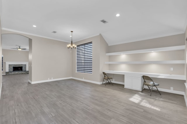 unfurnished office featuring visible vents, a ceiling fan, built in study area, wood finished floors, and a stone fireplace