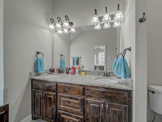 bathroom featuring a sink, toilet, and double vanity