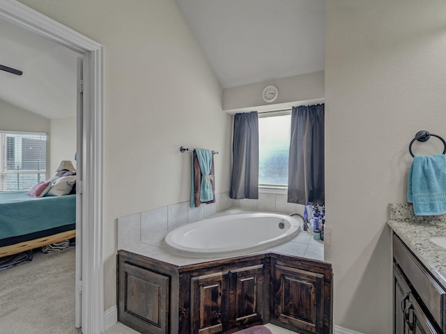 ensuite bathroom featuring lofted ceiling, vanity, ensuite bath, and a bath