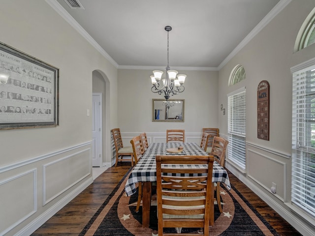 dining space with arched walkways, dark wood-style flooring, crown molding, a notable chandelier, and a decorative wall