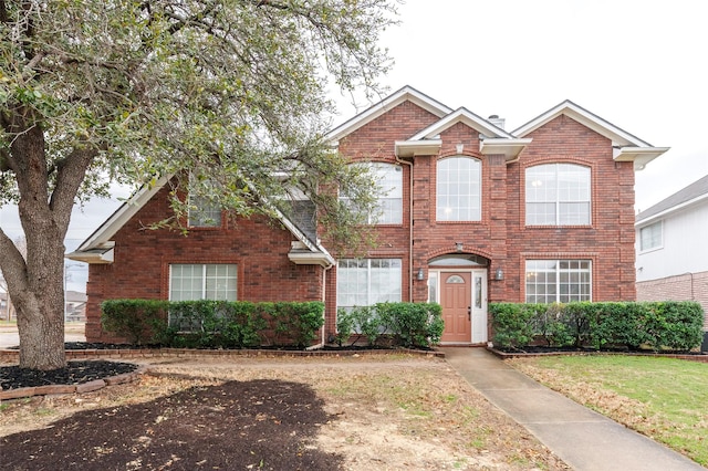 view of front of property featuring brick siding and a front lawn