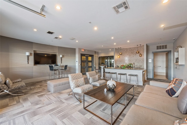 living area with light carpet, visible vents, and recessed lighting