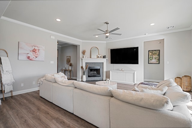 living room with ornamental molding, a fireplace, wood finished floors, and visible vents