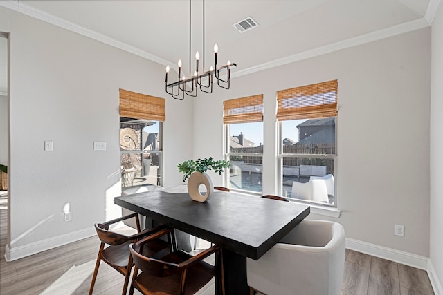 dining room featuring ornamental molding, baseboards, and wood finished floors