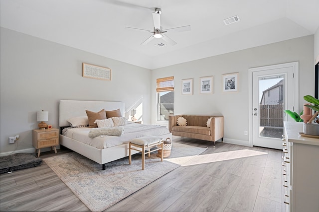 bedroom with access to exterior, lofted ceiling, visible vents, light wood-style floors, and baseboards