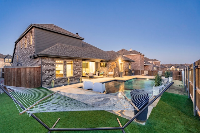 exterior space with a yard, a fenced backyard, a patio, and brick siding