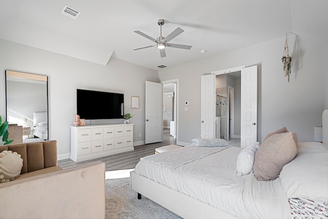 bedroom with wood finished floors, visible vents, and baseboards